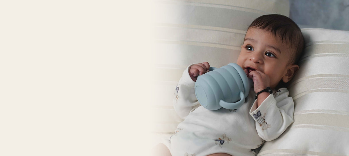 Baby sipping from a blue silicone training cup